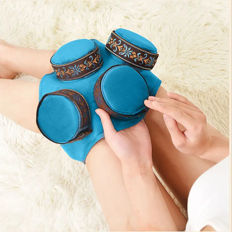 Blue fabric-covered portable moxa holder shown in a product display around a knee